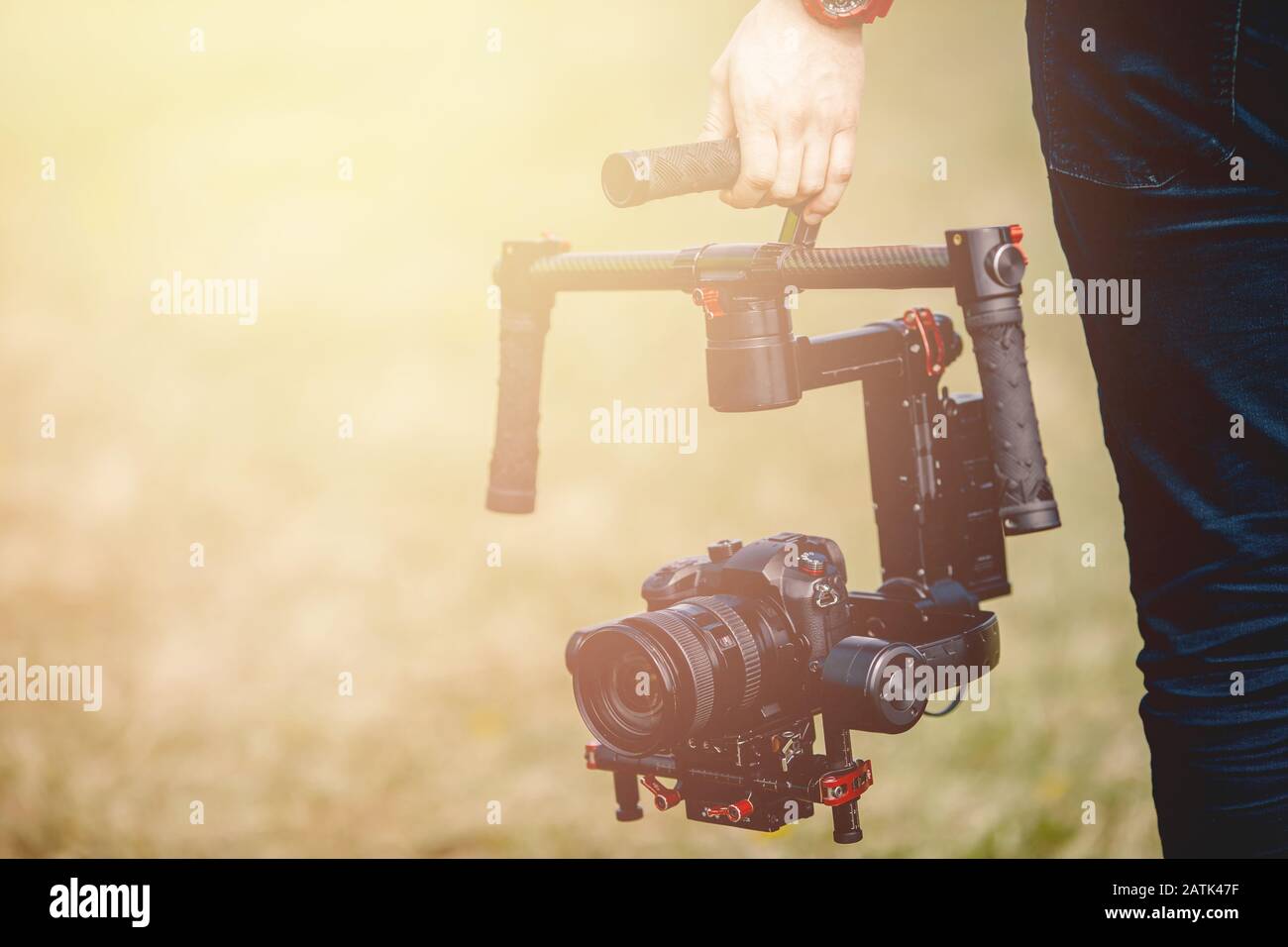 Videographer holds electronic stabilizer steadicam gimbal for DSLR camera Stock Photo