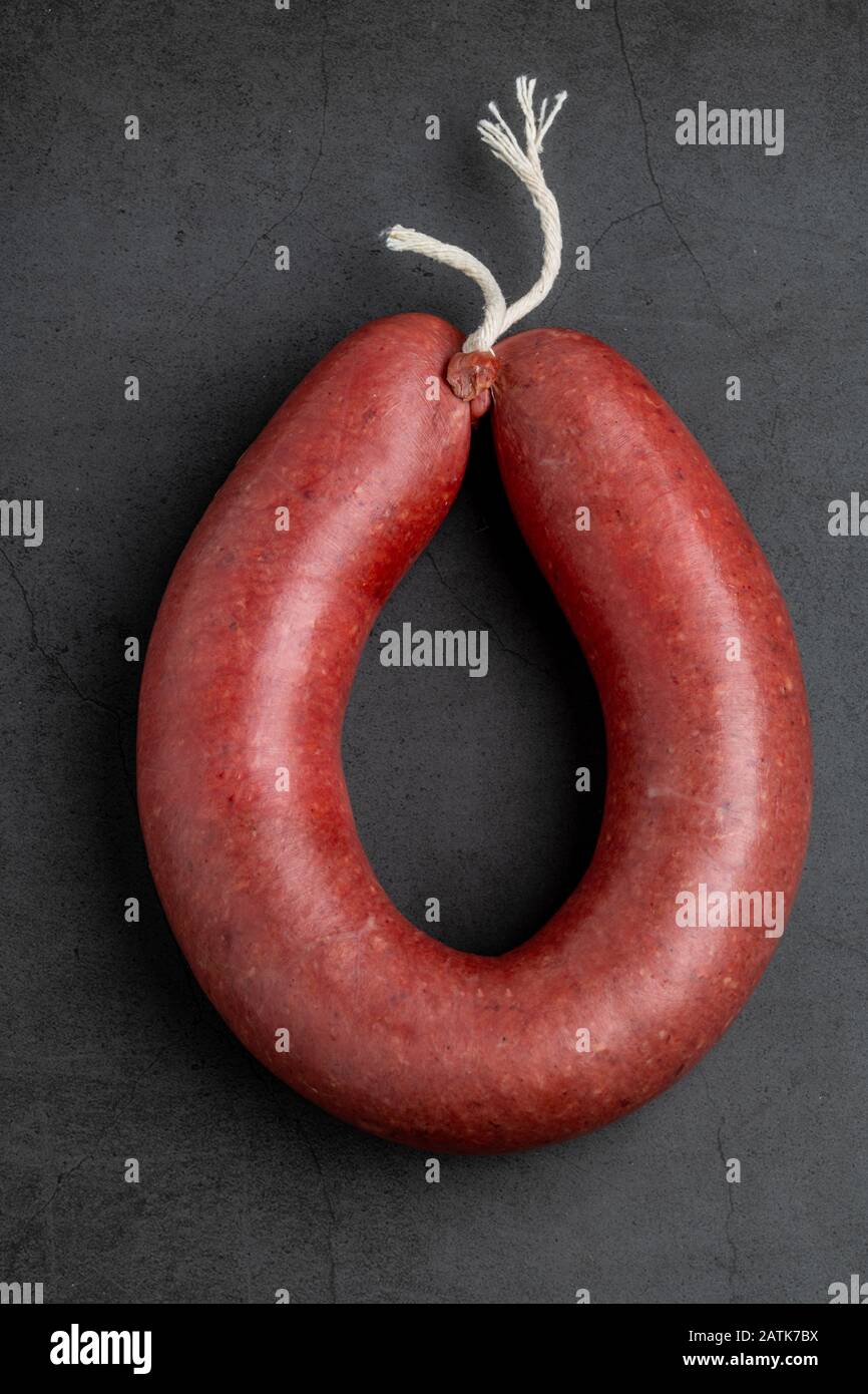 Turkish sausage kangal sausage. Dry spicy sausage on dark stone background. Stock Photo