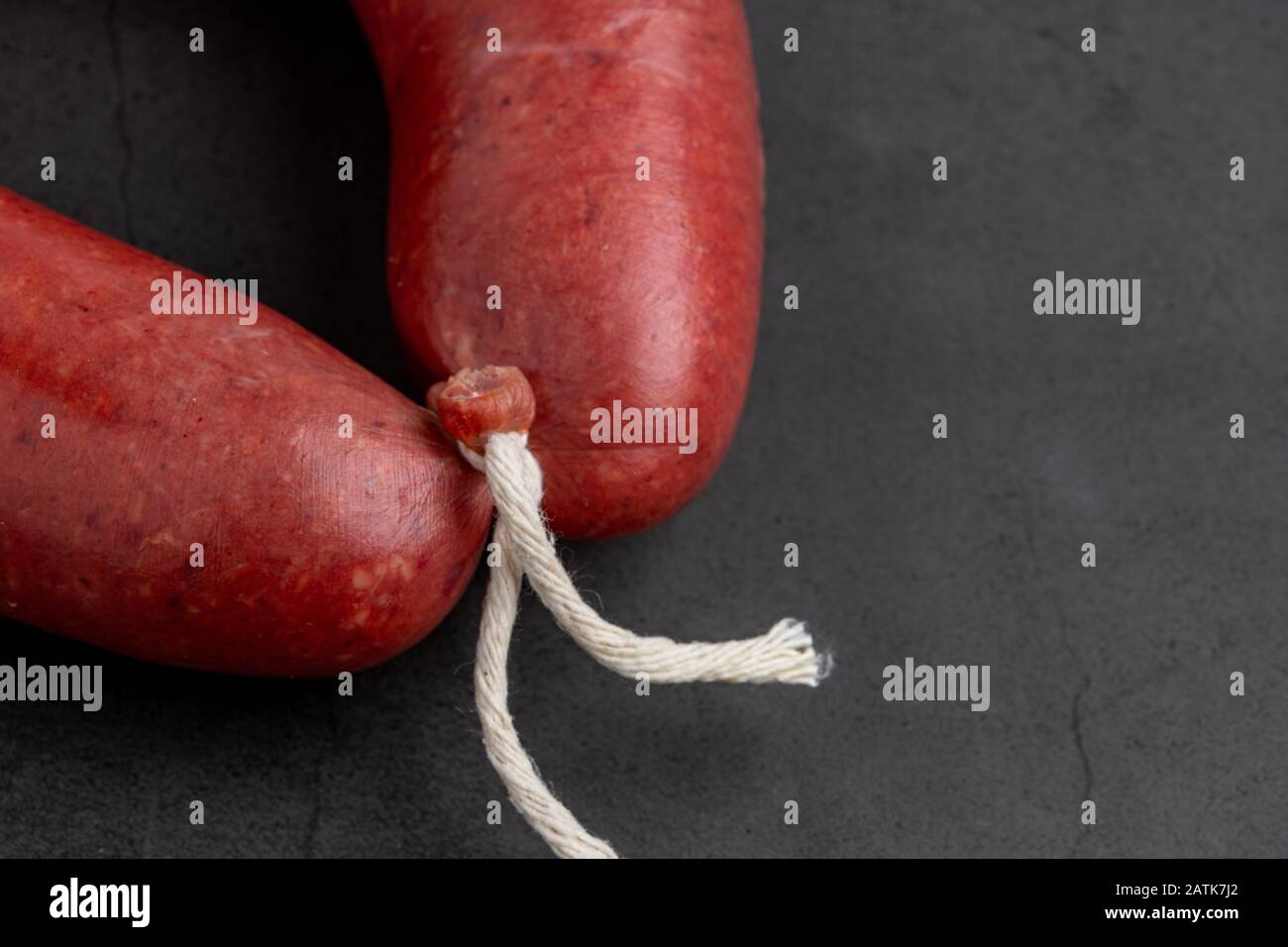 Turkish sausage kangal sausage. Dry spicy sausage on dark stone background. Stock Photo