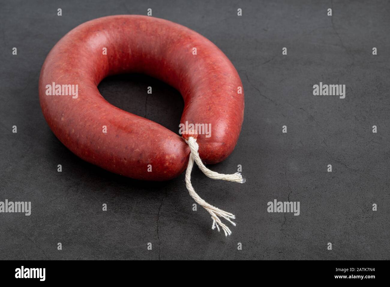 Turkish sausage kangal sausage. Dry spicy sausage on dark stone background. Stock Photo