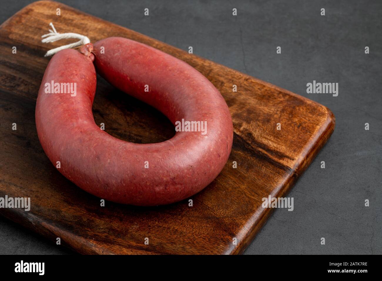 Turkish sausage kangal sausage. Dry spicy sausage on dark stone background. Stock Photo