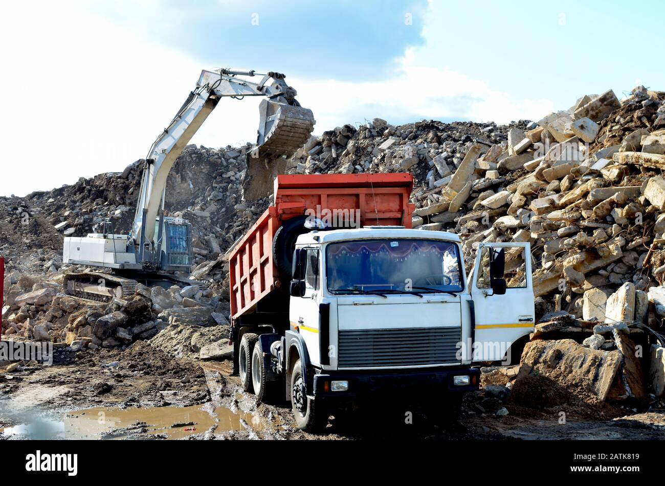 Dump truck unloading of broken concrete slabs demolition waste on 