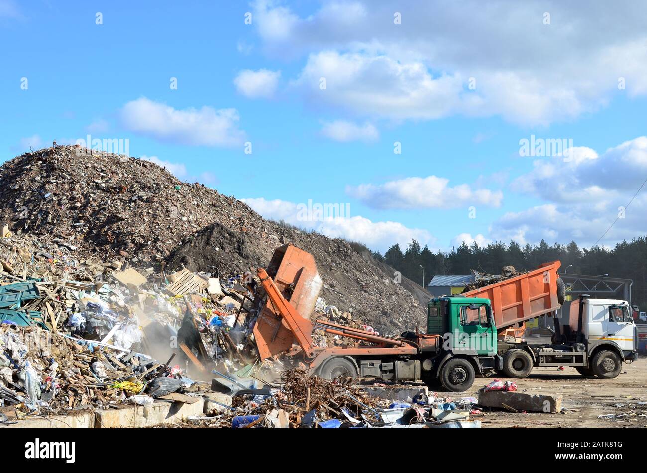 Garbage truck unloads construction waste from container at the landfill