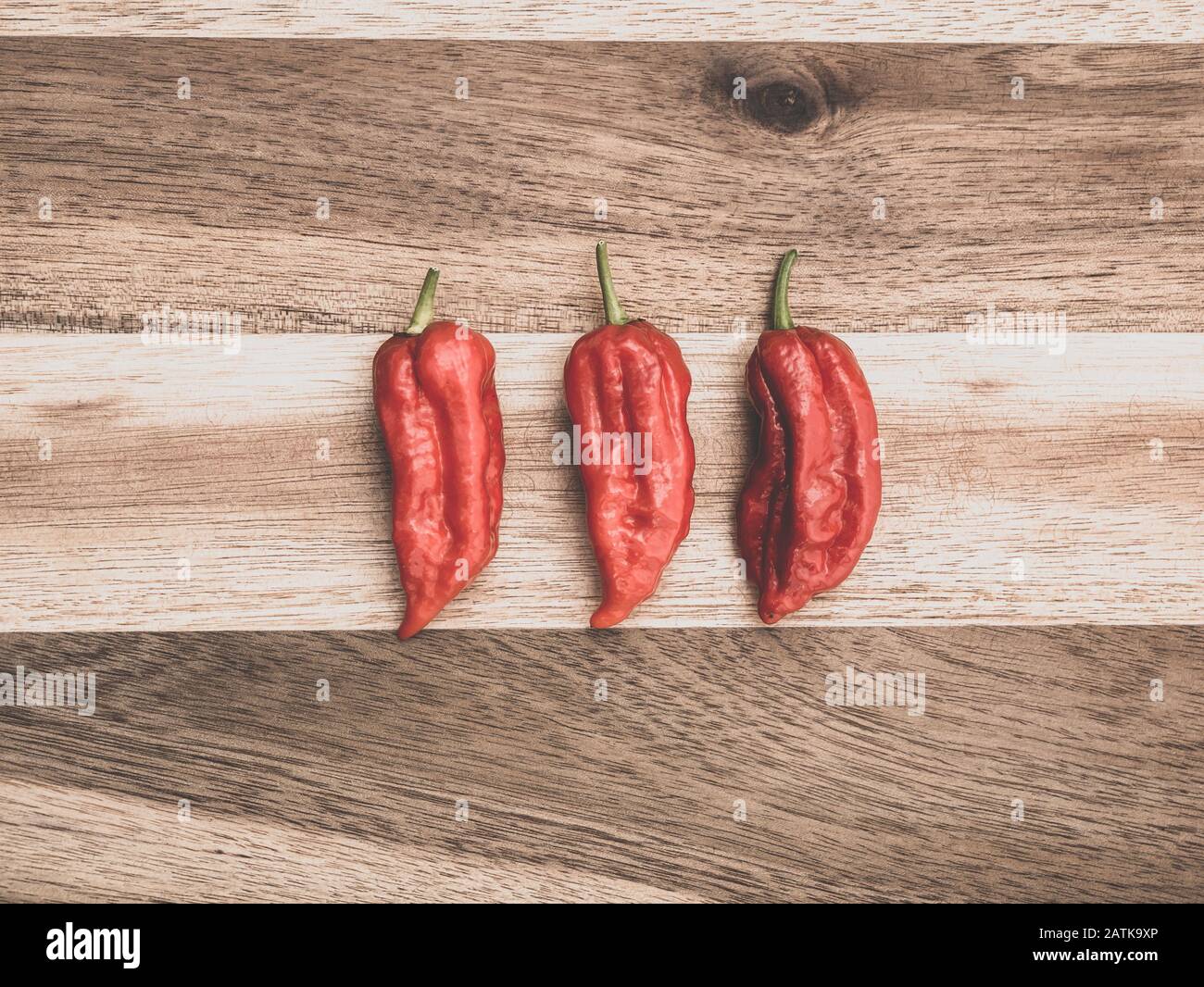 Decoration of chili peppers on wodden board. Three Bhut jolokia on ...