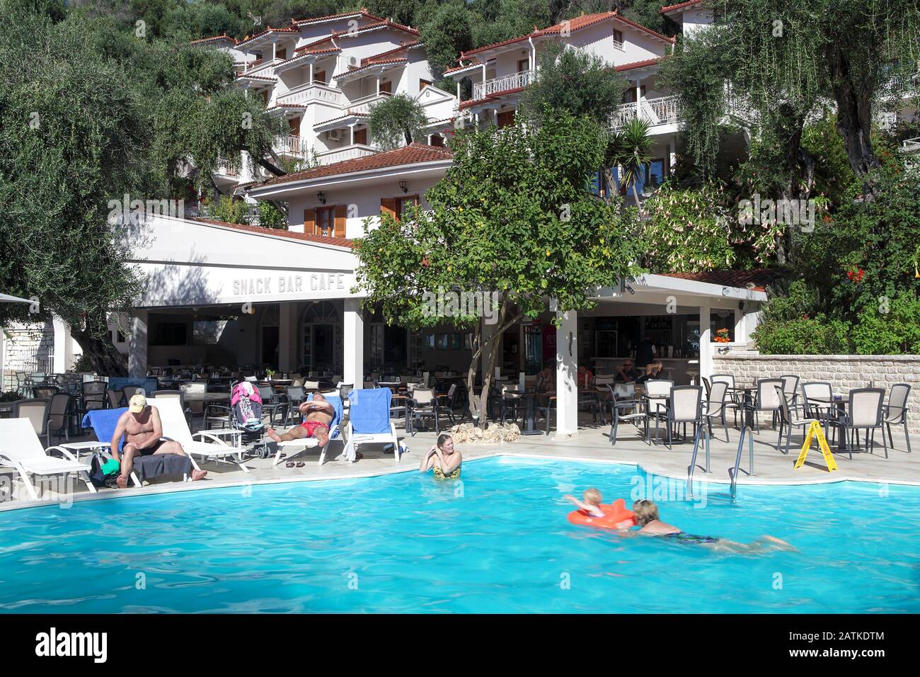 Holidaymakers at the Valtos Beach Hotel in Barga enjoying relaxing and swimming in the outdoor pool on glorious October day in north-west Greece. Stock Photo