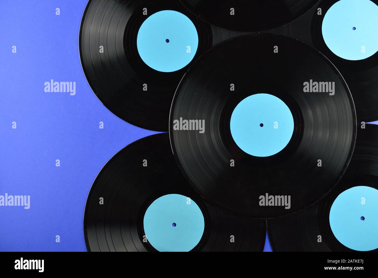 border of old black vinyl records with blank cyan labels on blue background Stock Photo