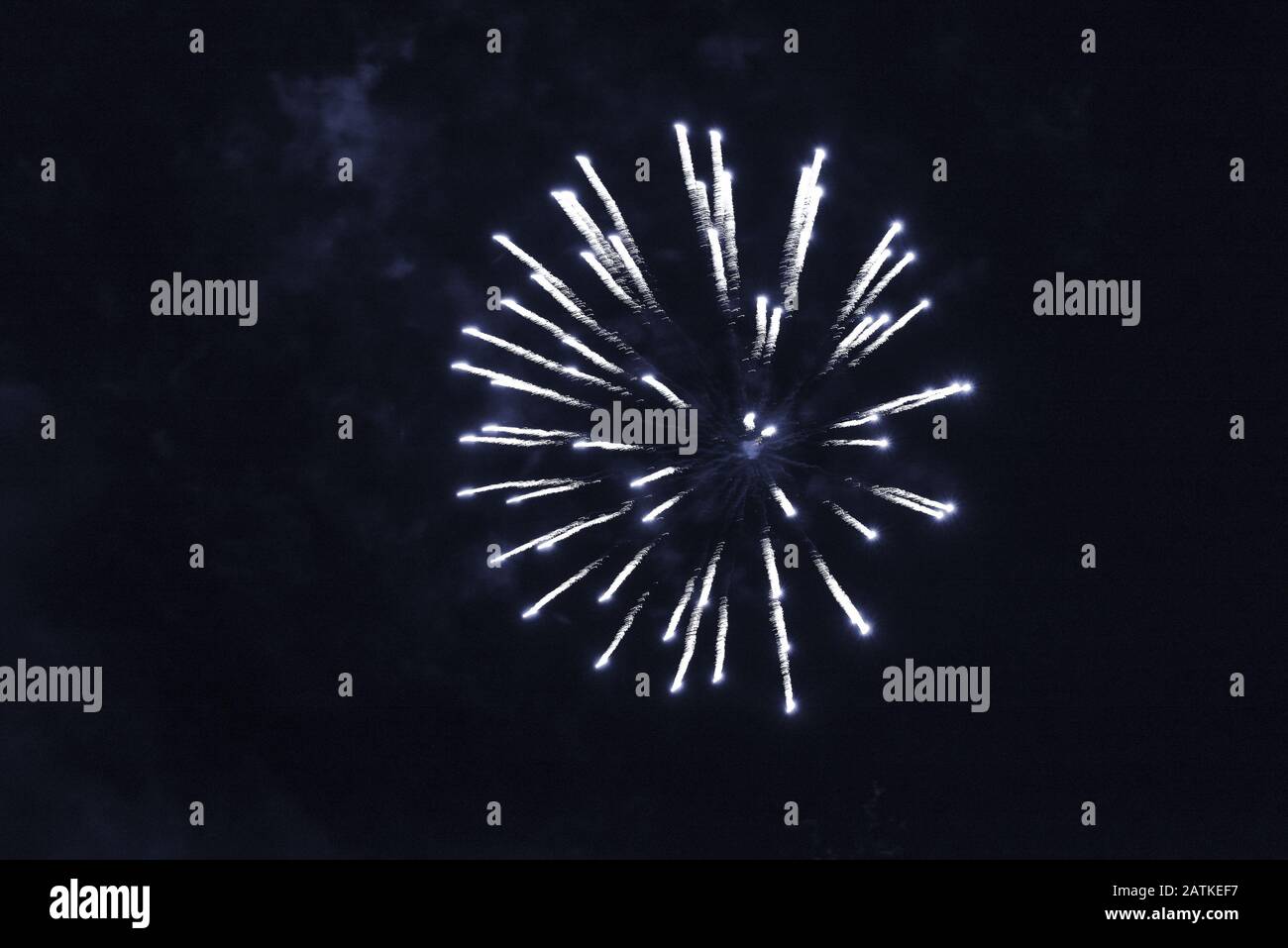 Cheap bluish fireworks against the dark sky. Stock Photo
