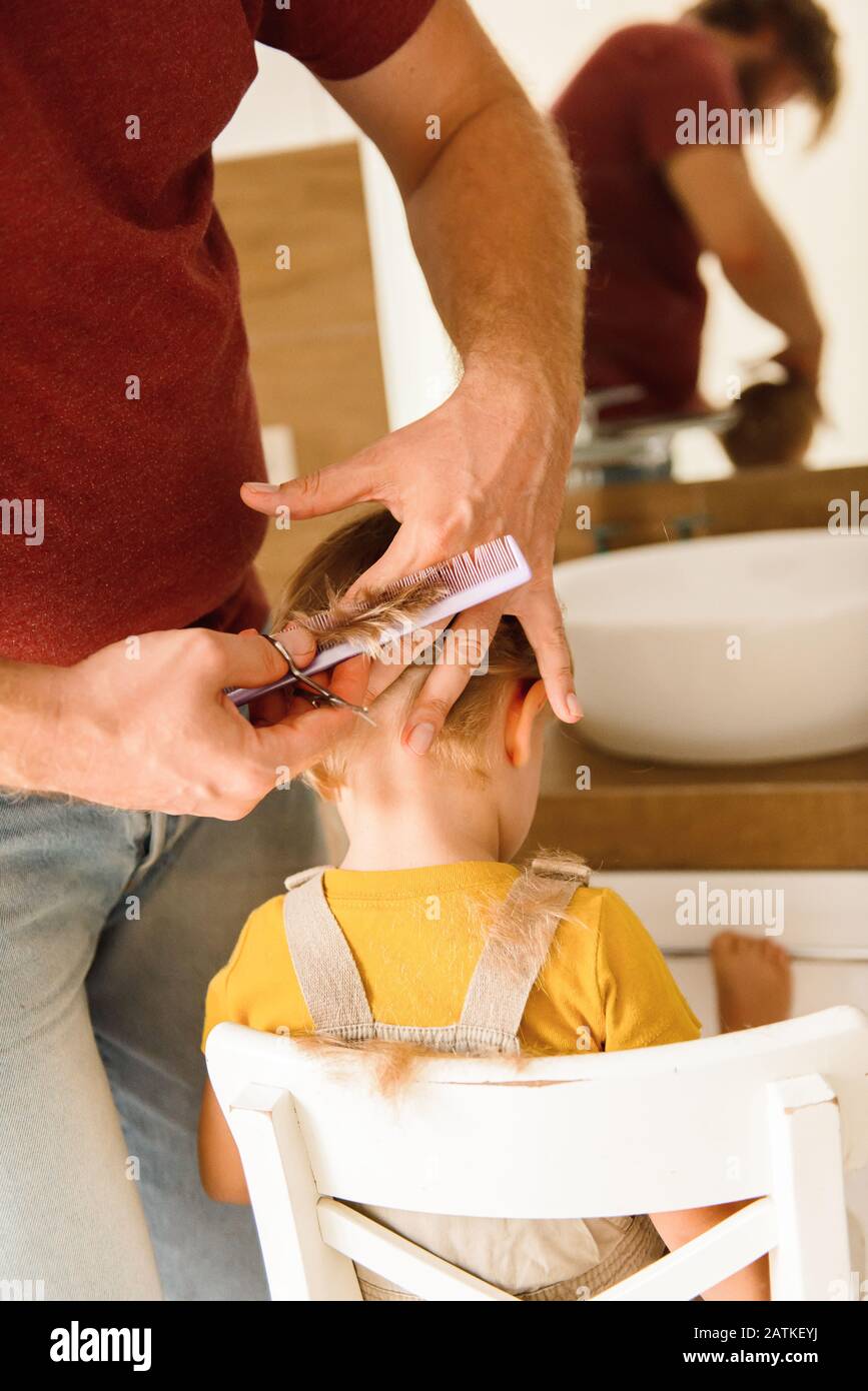 Dad cutting hair to little son Stock Photo