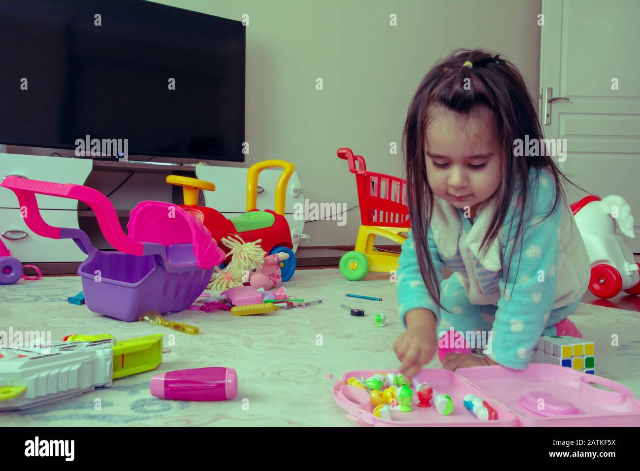 Little girl playing with toys on the floor Stock Photo