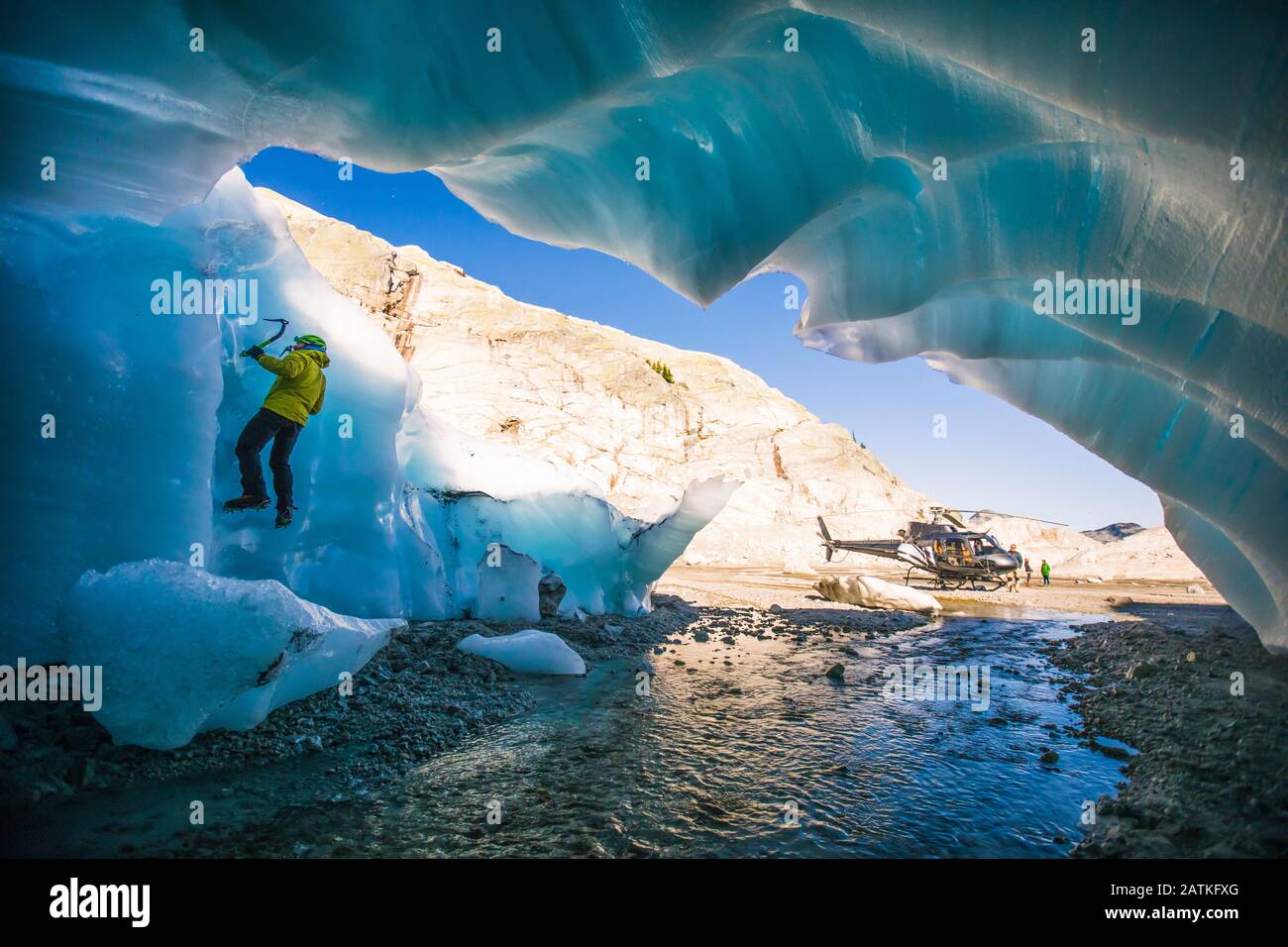 Man ice climbing on glacial ice during adventure helicopter tour Stock Photo