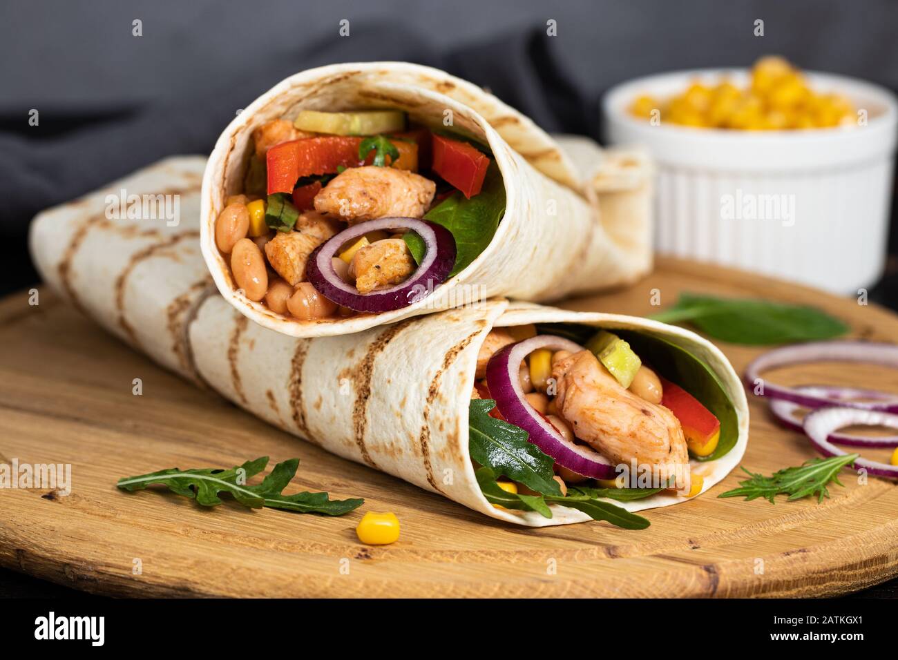 Burritos wraps with chicken and vegetables on dark background. Mexican