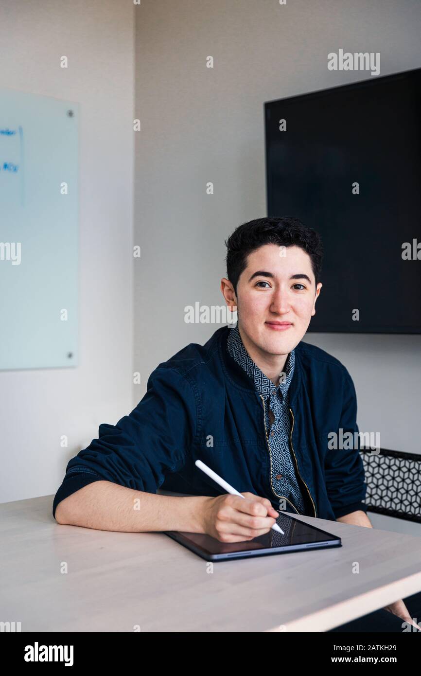 businessman writing with digitized pen on graphics tablet at table in office Stock Photo