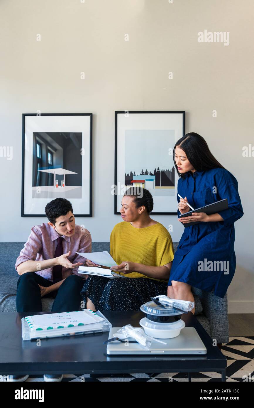 business colleagues discussing over documents in office Stock Photo