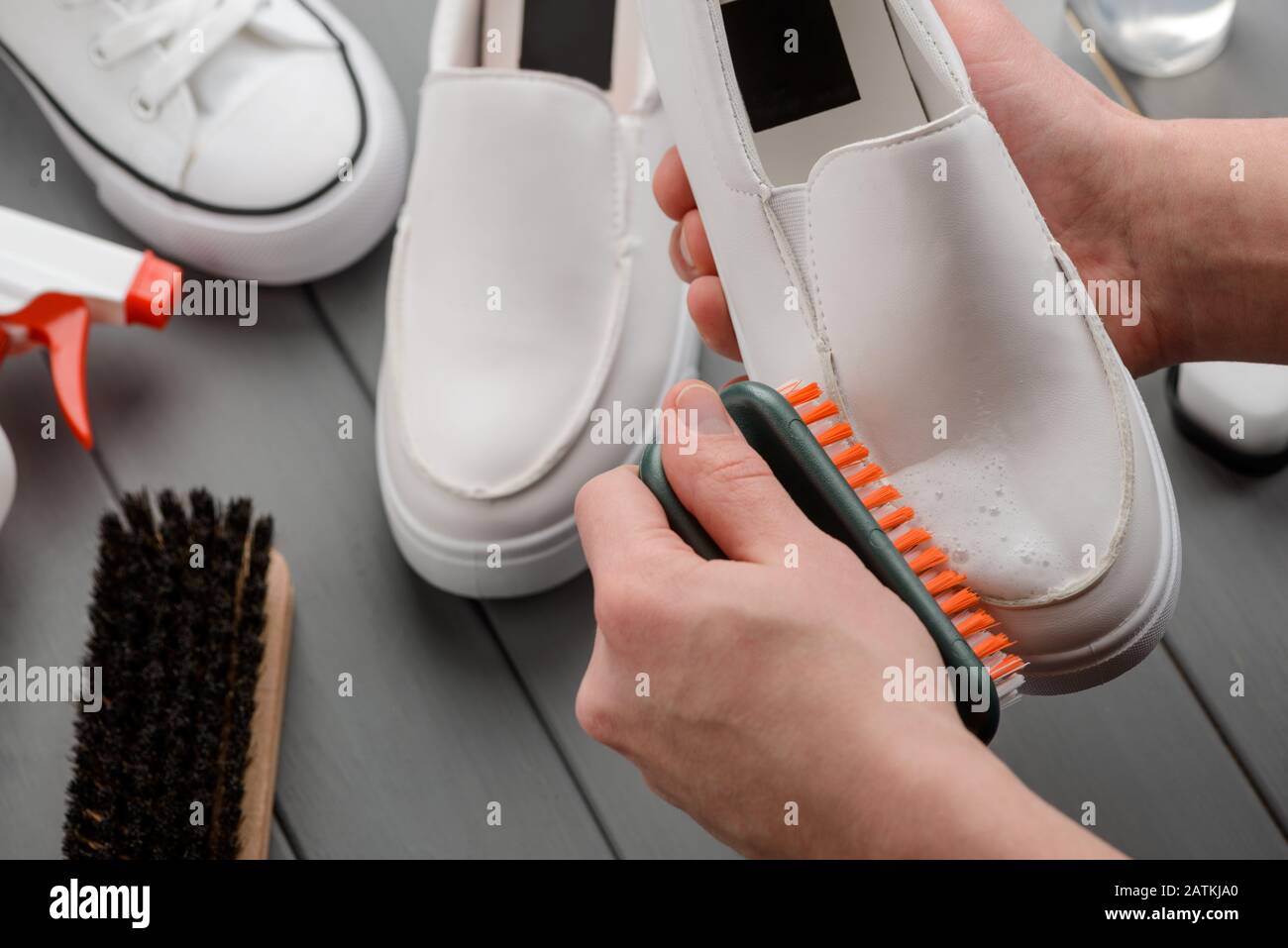 Man cleaning leather loafers, removing dirt with a brush and foam Stock Photo Alamy