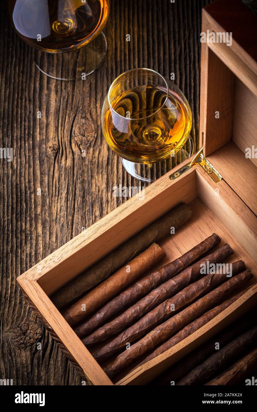 humidor with quality cigar and cognac on an old wooden table Stock Photo
