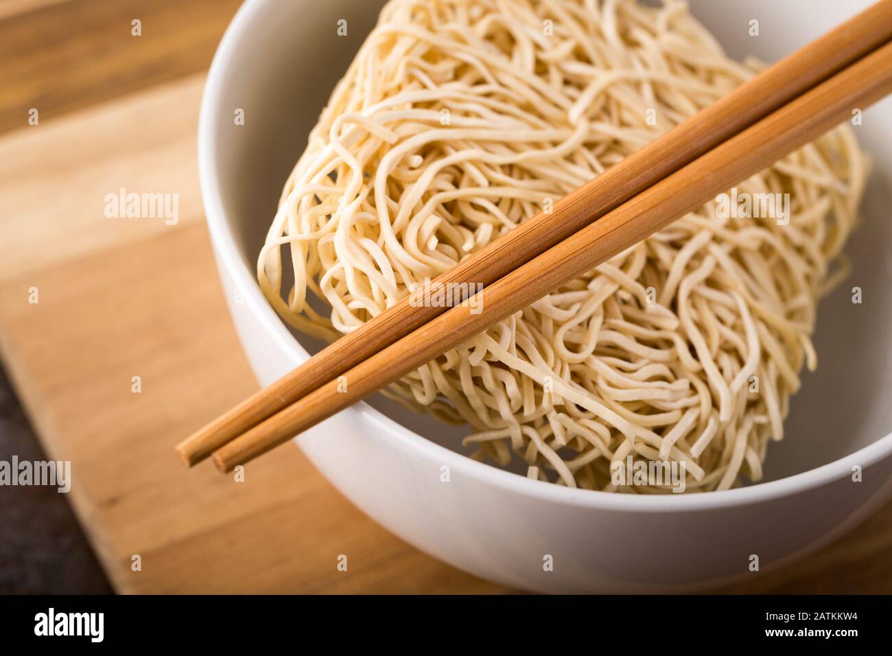 Chinese dried noodles in a bowl. Bamboo sticks. Asian cuisine. Stock Photo