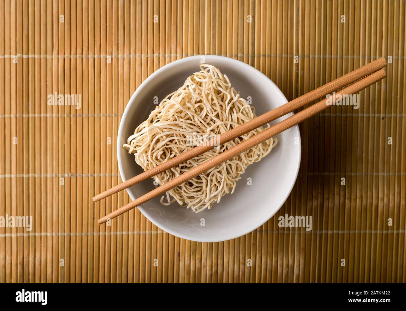 Chinese dried noodles in a bowl. Bamboo sticks. Asian cuisine. Stock Photo
