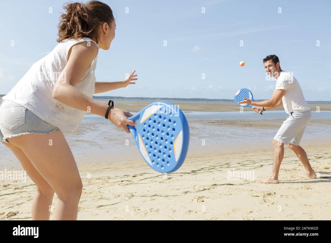couple playing beach tennis game on the sand Stock Photo - Alamy
