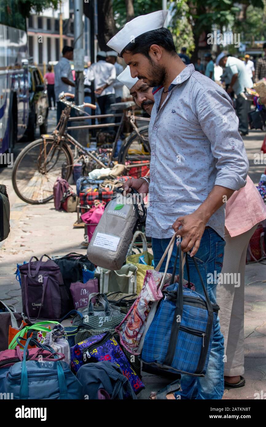 India, Mumbai aka Bombay. Dabbawalas (aka dabbawallas or dabbawallahs, tiffin wallahs) deliver lunches all over the city every day. Stock Photo