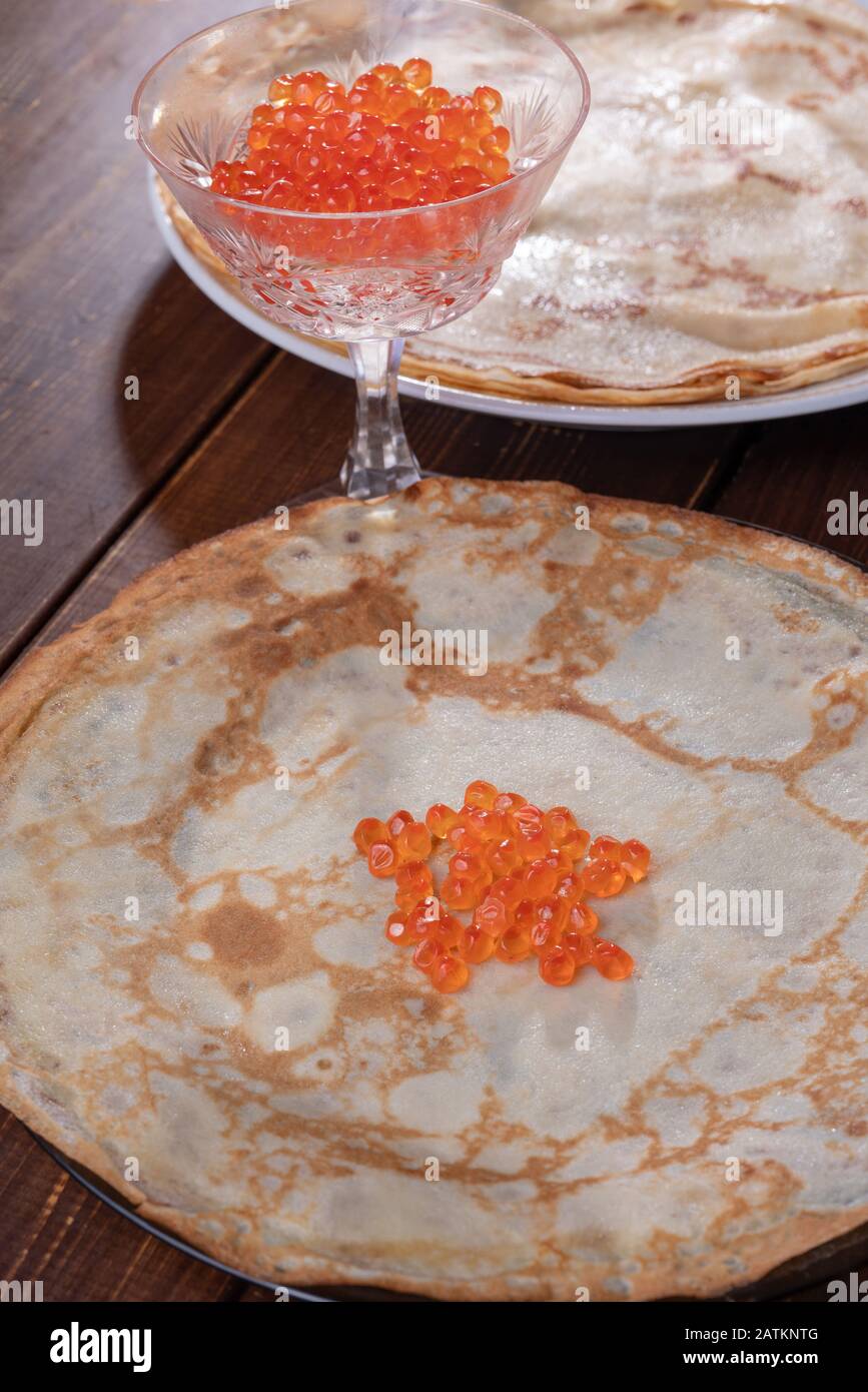 Pancakes with fish roe   of chum salmon  as filling - on brown boards Stock Photo