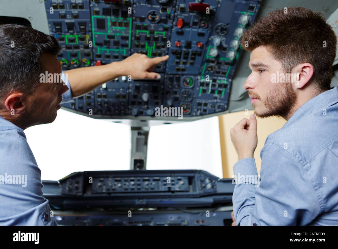 two flight engineers talking in cockpit Stock Photo