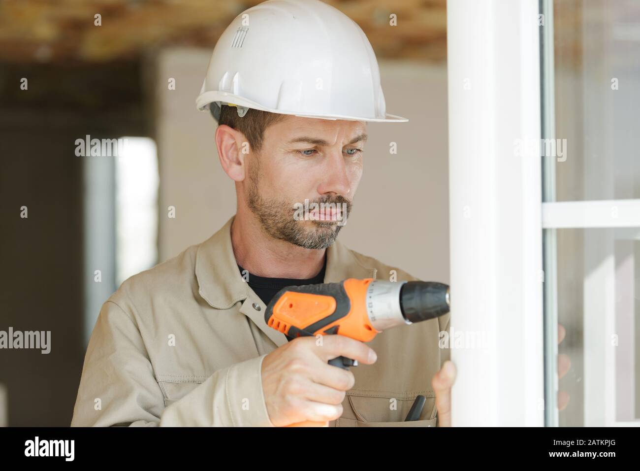 male glazier using cordless drill to install windows Stock Photo Alamy