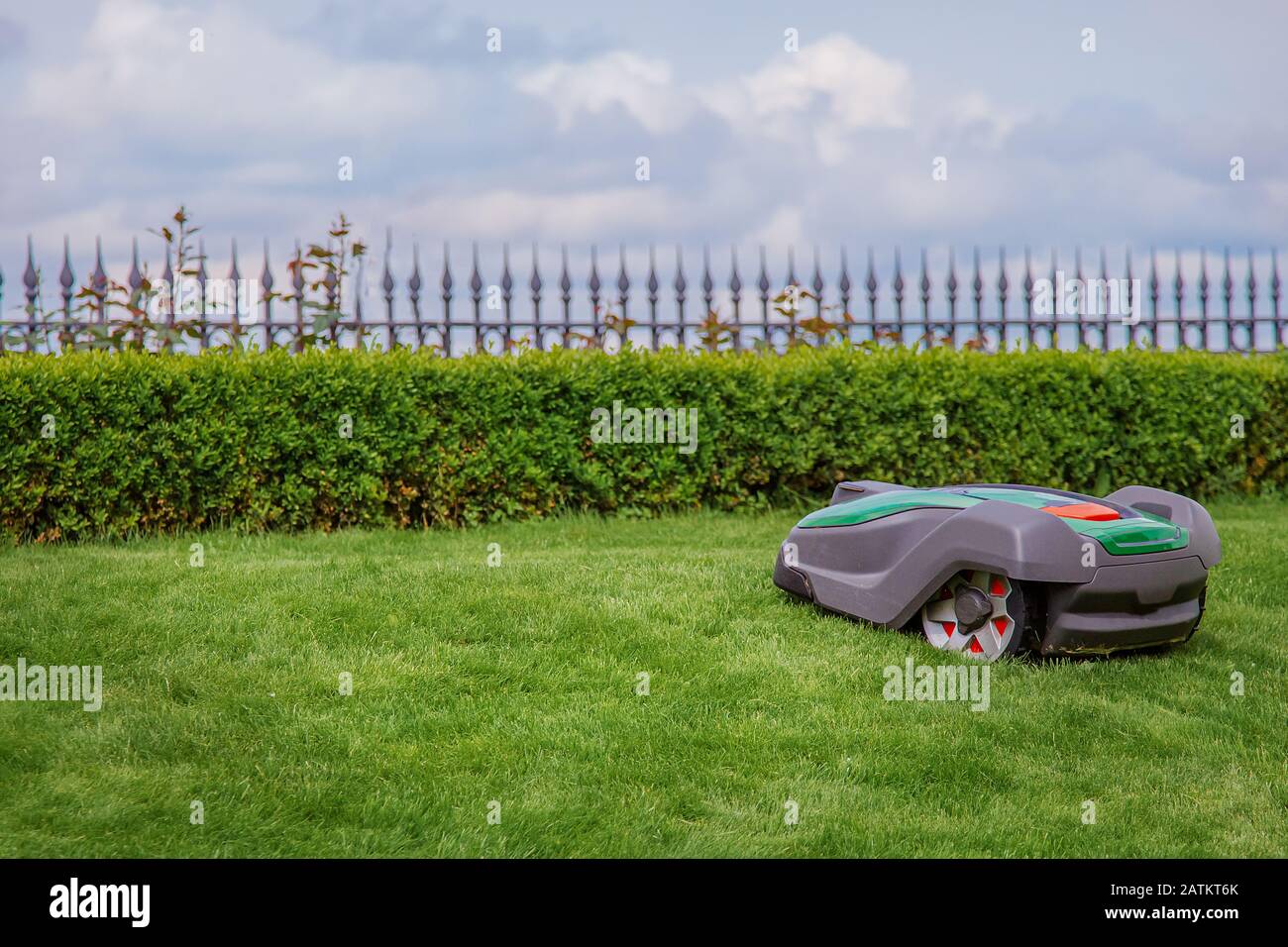 Robotic lawn mower on grass, side view. Garden modern remote technology