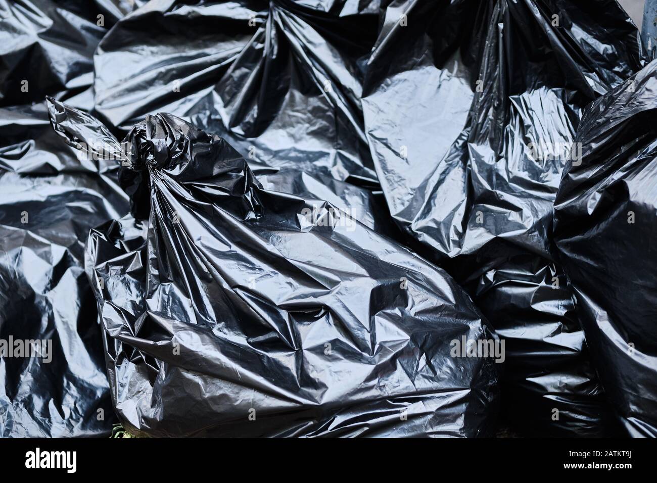 Black garbage bags lie on the ground. close up. Stock Photo