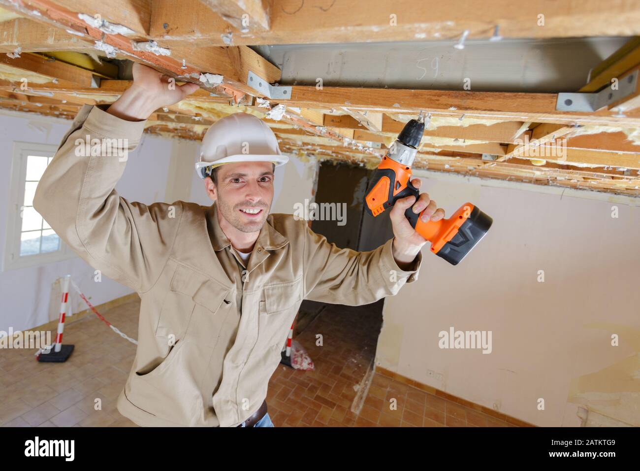 handyman using cordless drill to the ceiling Stock Photo