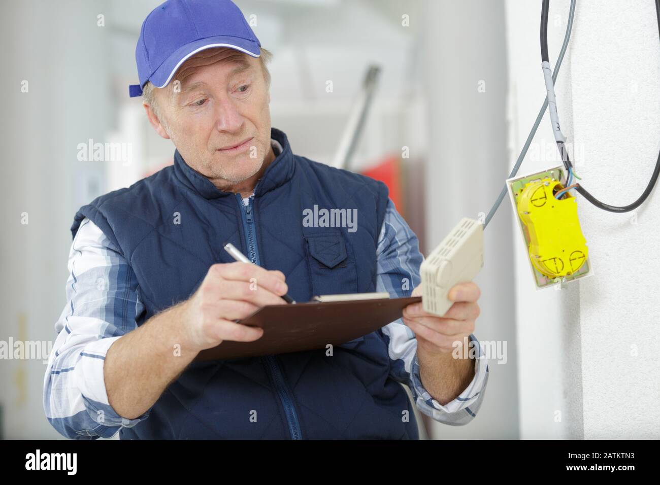 mature electrician with multimeter probe Stock Photo