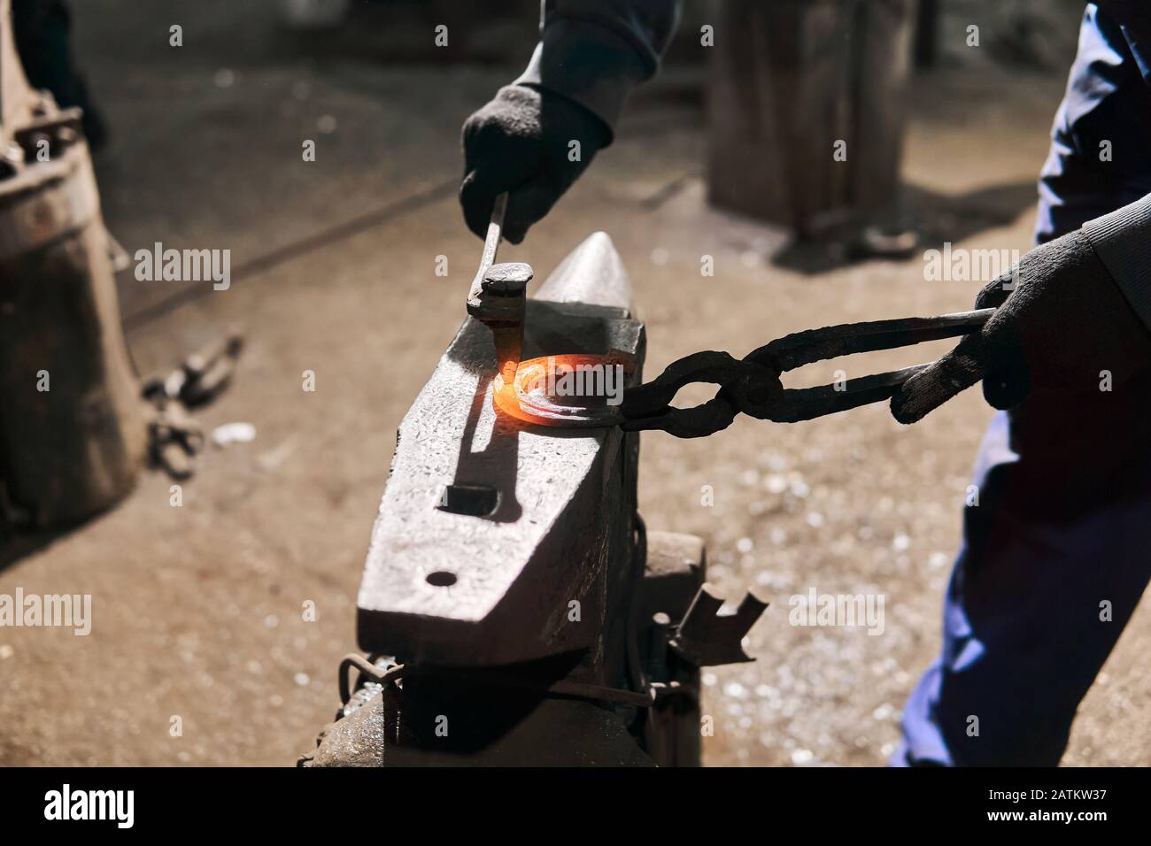 blacksmith a horseshoe on the anvil with chisel, close