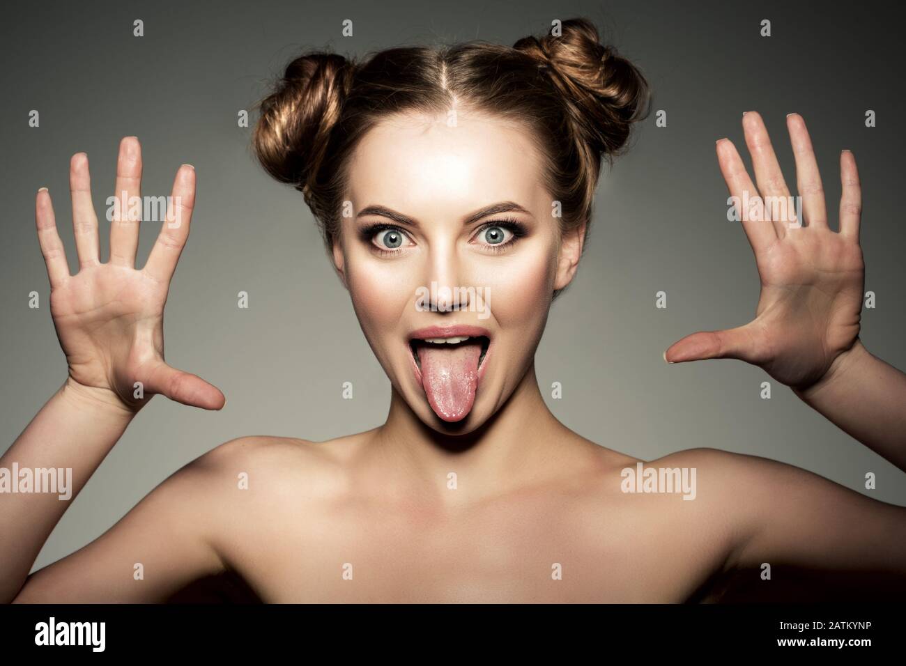 Emotional girl. Beautiful modern model shows tongue Positive woman hipster. Emotions on face. Stock Photo