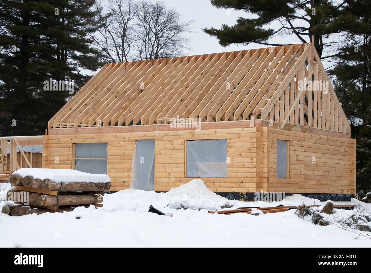 A prefabricated log home under construction during the winter in Speculator, NY USA in the Adirondack Mountains. Stock Photo