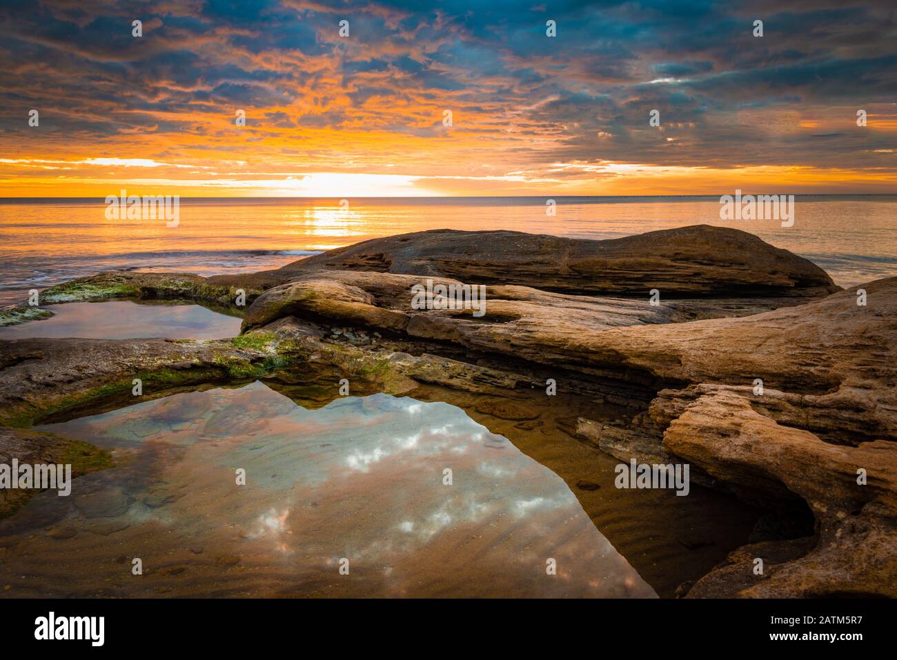 Picturesque sunrise over a rocky beach. Stock Photo