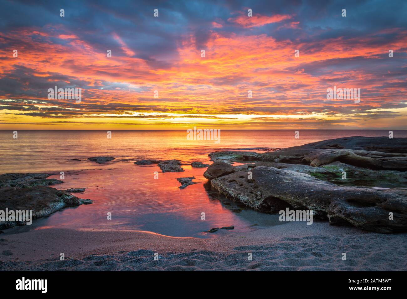 Picturesque sunrise over a rocky beach. Stock Photo