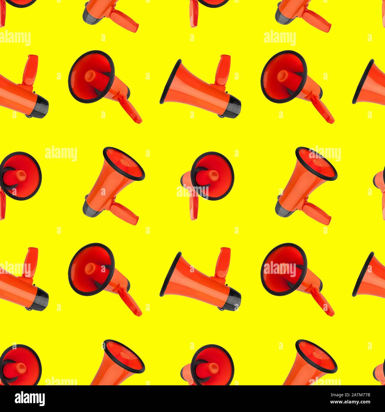 Seamless pattern of orange megaphones on yellow background isolated