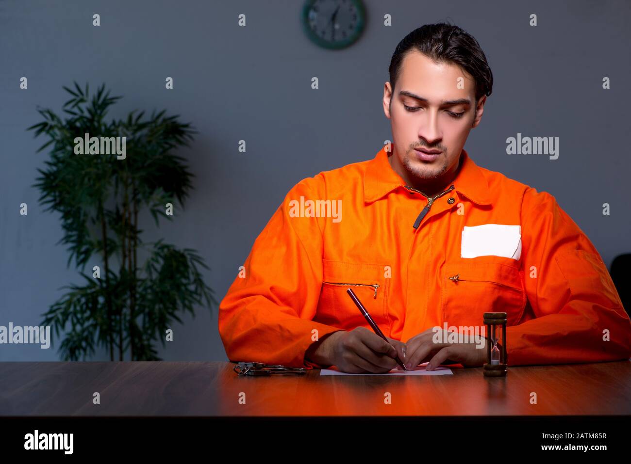 The young convict man sitting in dark room Stock Photo