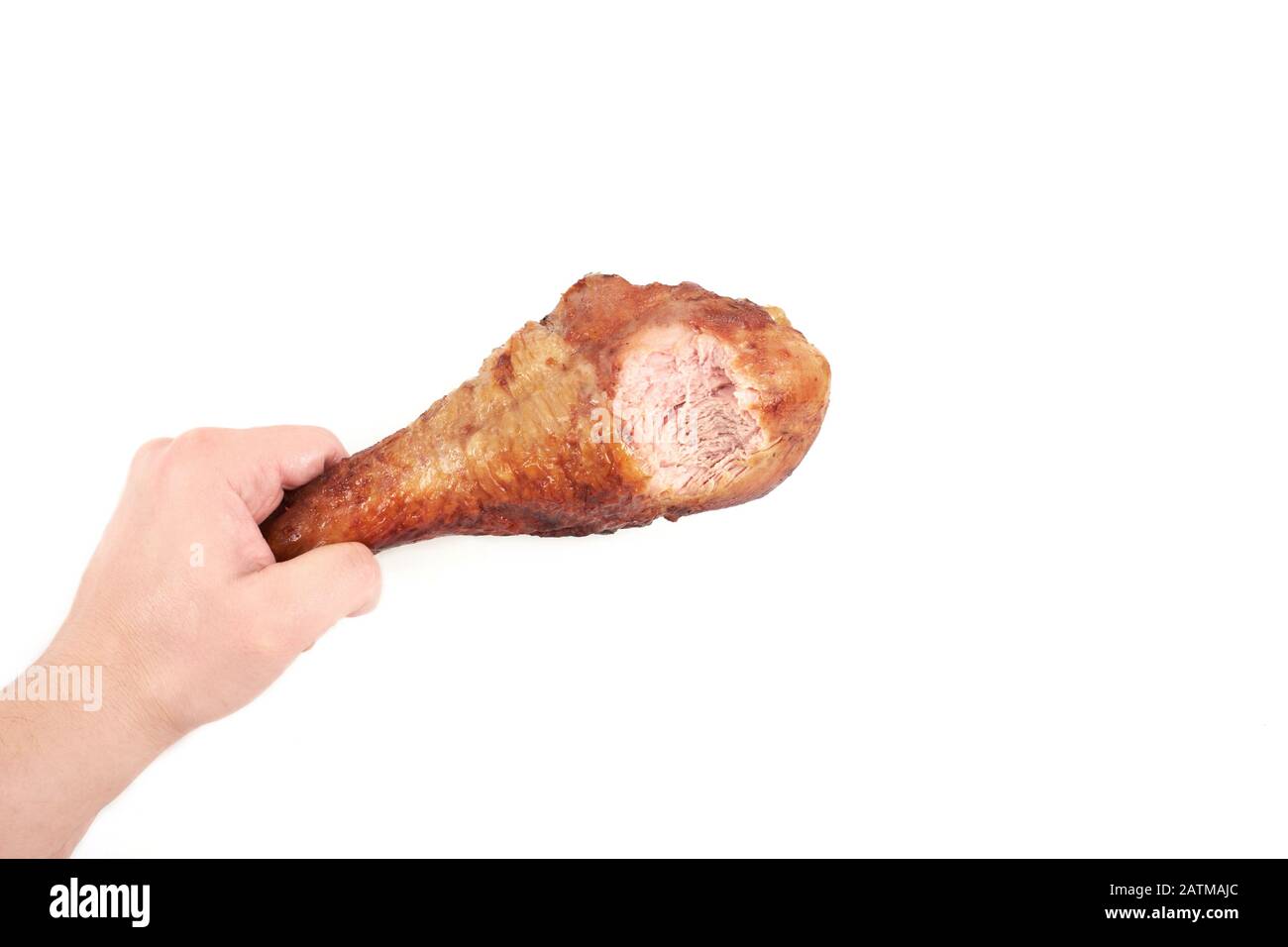 hand holding roasted turkey leg with bite taken , isolated on white