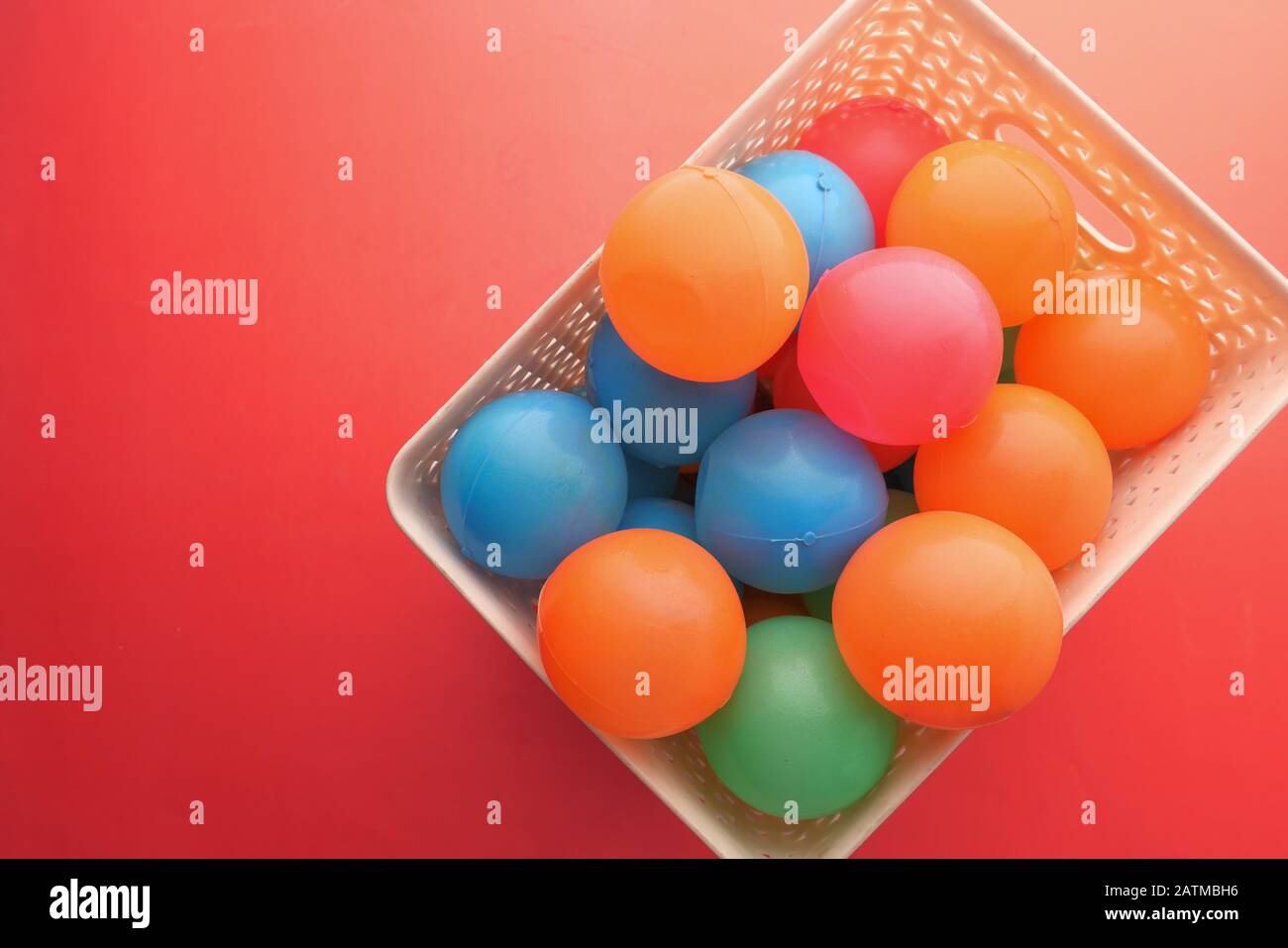 Close up of multi color ball on red background Stock Photo - Alamy