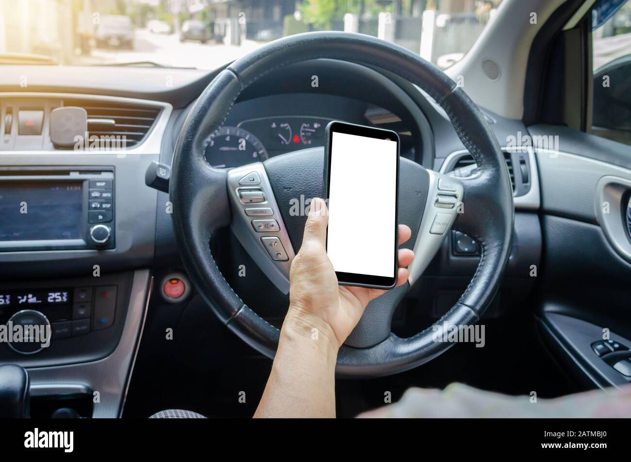 Women's hand holding a mobile phone in the car.Clipping path Stock Photo