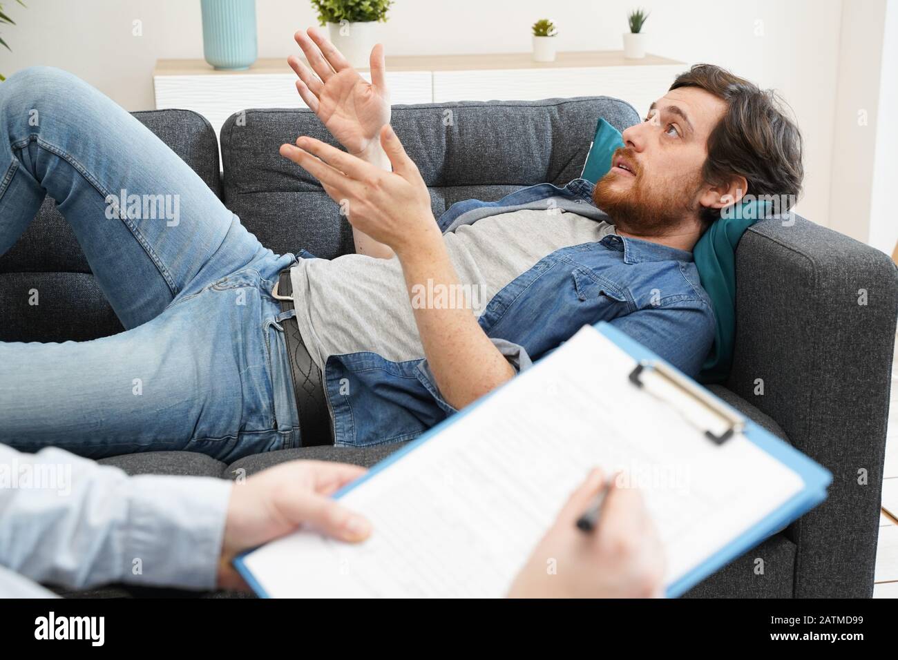 Psychologist doctor taking notes during psychotherapy session Stock Photo