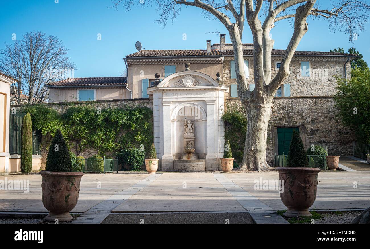 Large  formal courtyard garden, Perne les fontaines, with large pots and plane trees ,provence south of France. Stock Photo