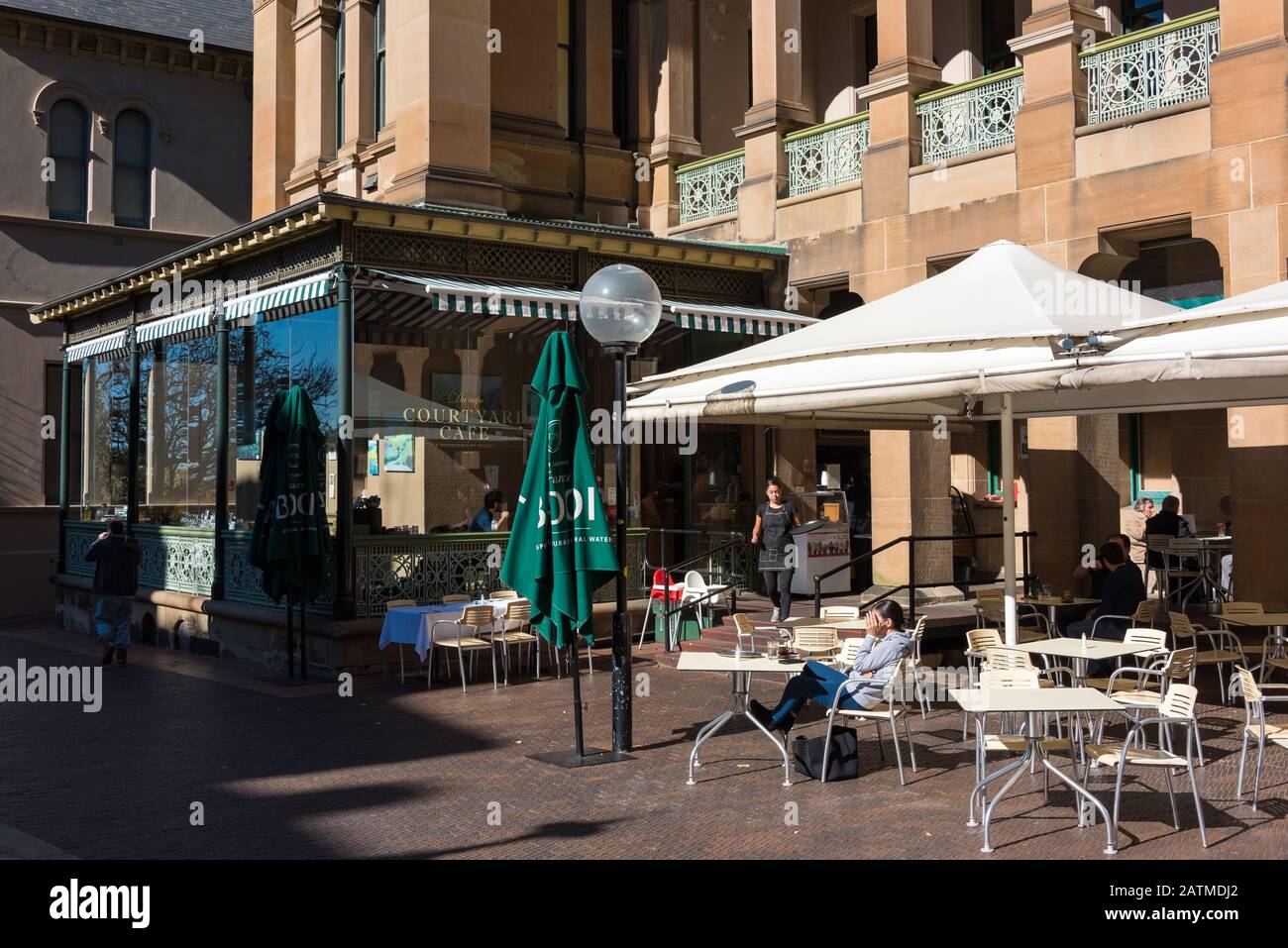 Sydney, Australia - July 3, 2016: Courtyard cafe with people relaxing and waitress bringing patrons order. Sydney Eye Hospital Courtyard cafe Stock Photo