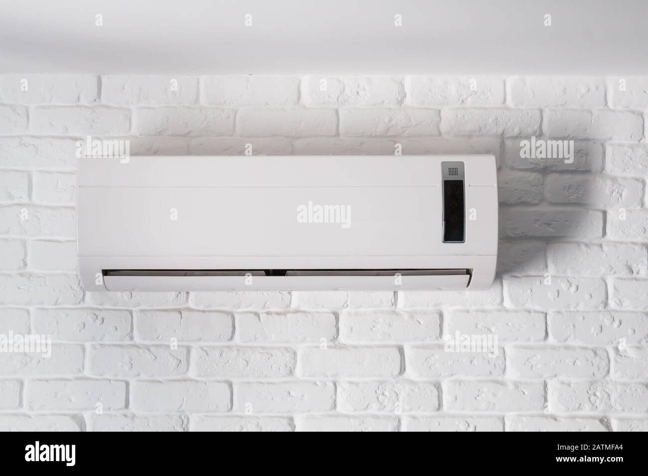 Air conditioner indoor unit mounted on loft style brick wall Stock Photo