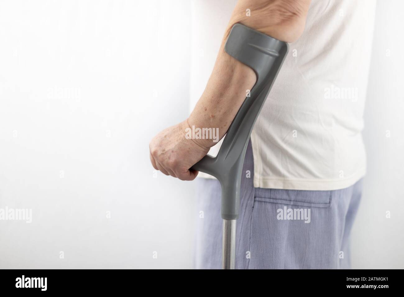 Person with medical walking stick, crutches over white background Stock Photo