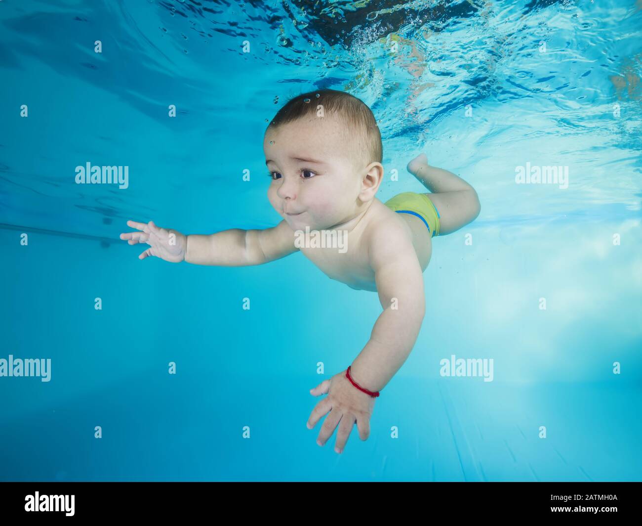 boy learns to dive underwater in a swimming pool Stock Photo