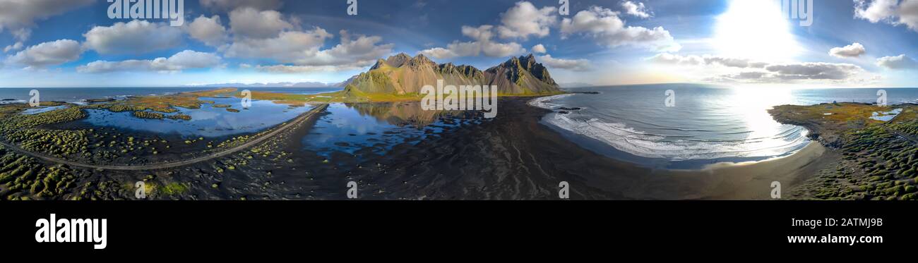 Epic aerial drone view flying over landscape of the black sand beach in Stokksnes on a sunny day. Vestrahorn mountain in the background. Nature and ec Stock Photo