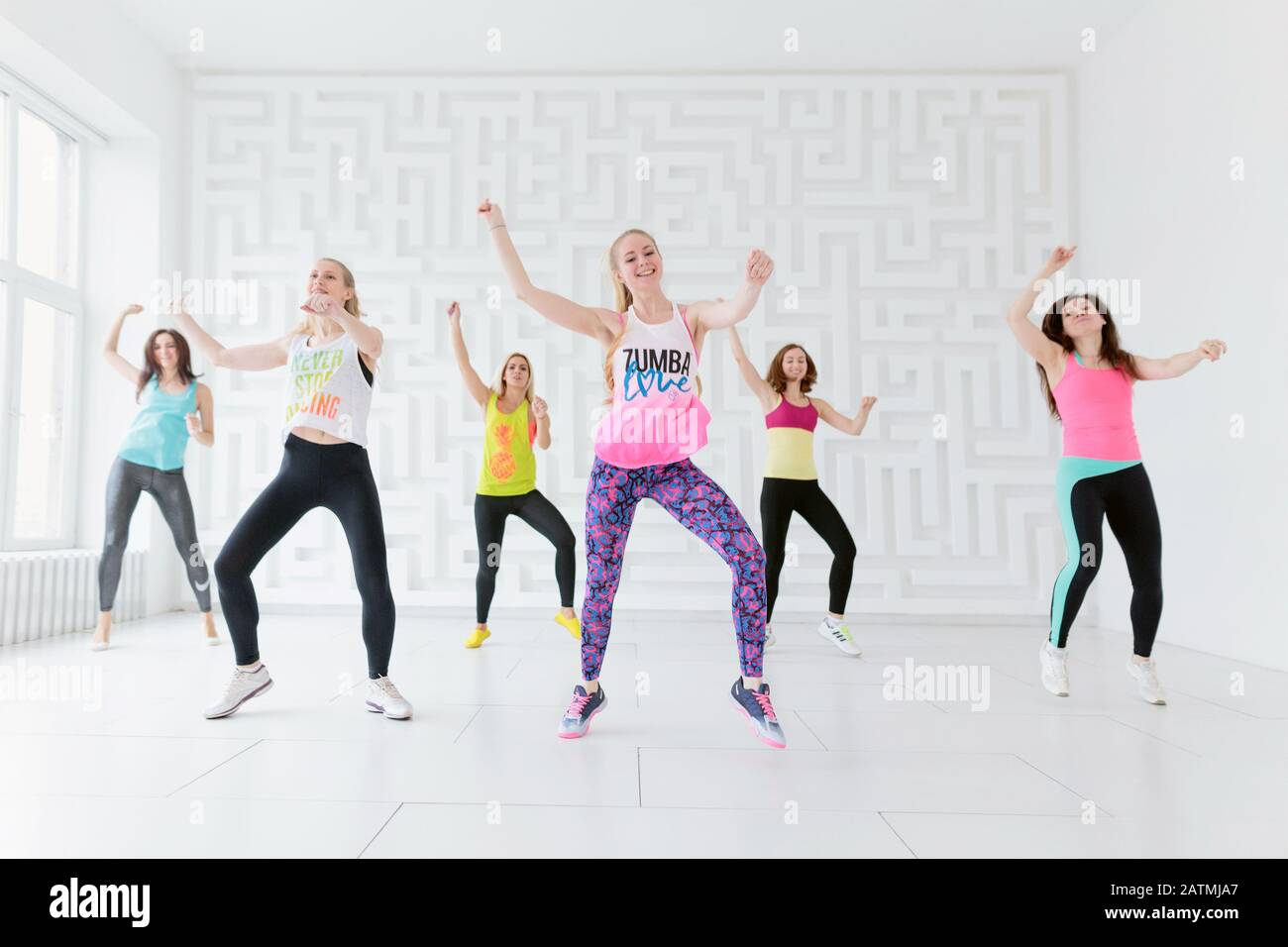 Group of young women in sportswear at Zumba dance fitness class in white  fitness studio Stock Photo - Alamy