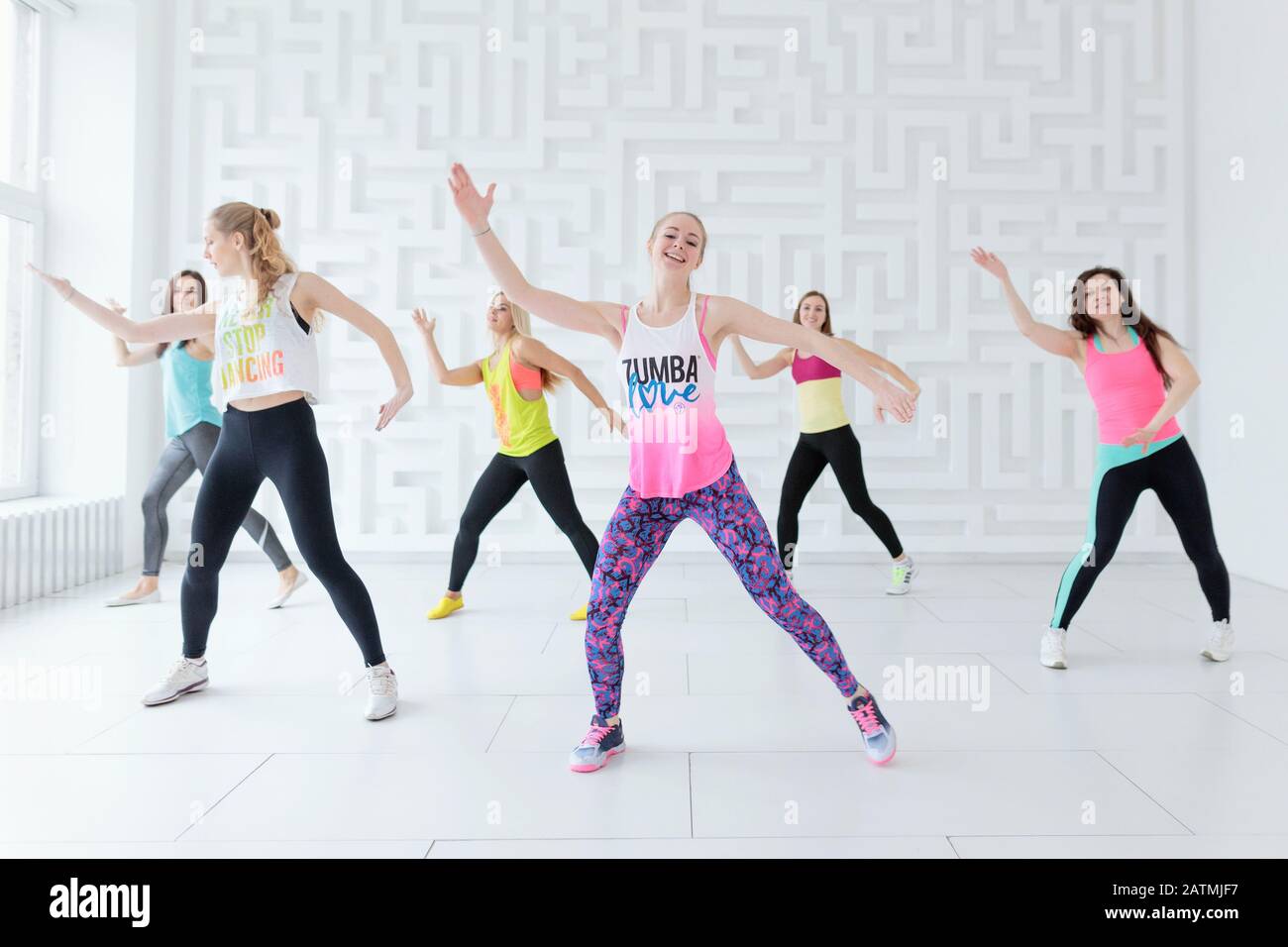 Group of young women in sportswear at Zumba dance fitness class in white  fitness studio Stock Photo - Alamy