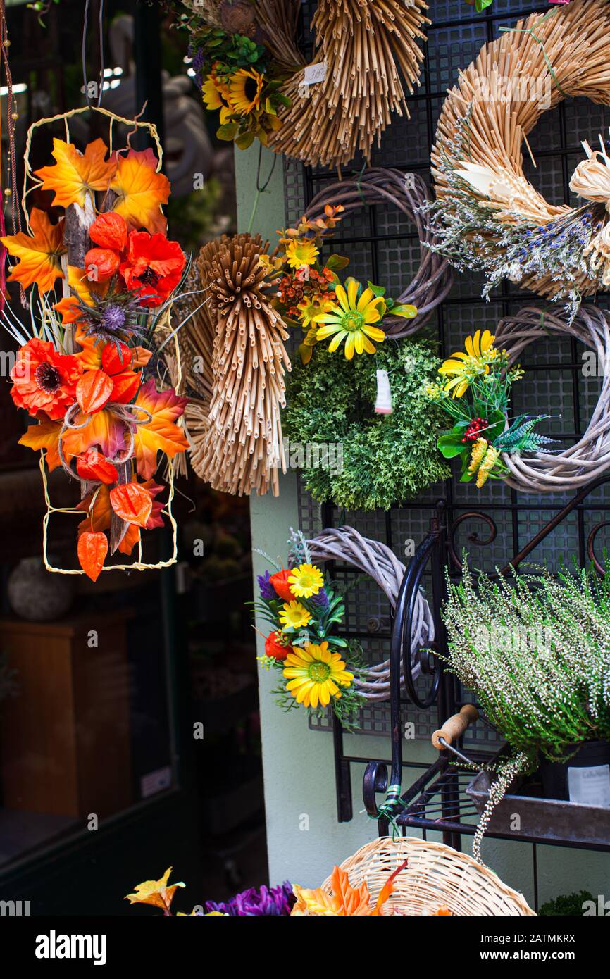 Small business concept. Decor shop window with creative festive floral  wreaths in autumn Stock Photo - Alamy, image size:866x1390